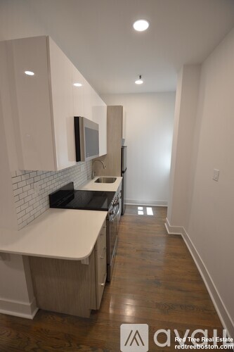 A kitchen with white cabinets and a white counter top.
