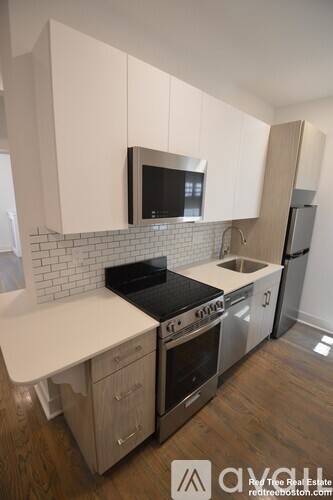 A kitchen with white cabinets and a black stove top oven.