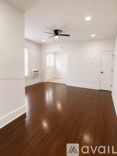 A room with wooden floors and a ceiling fan.