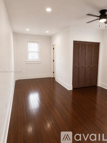 A room with wooden floors and a ceiling fan.
