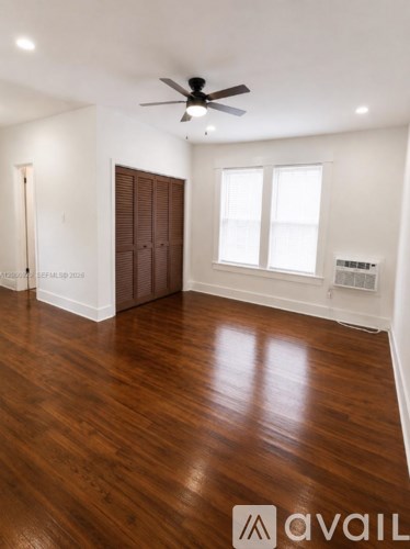A room with wooden floors and a ceiling fan.