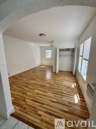 A room with wooden flooring and white walls.