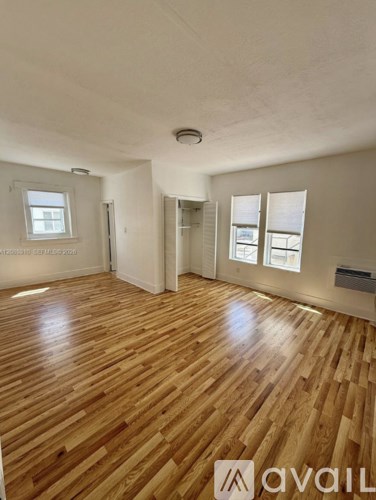 A room with wooden flooring and a window.
