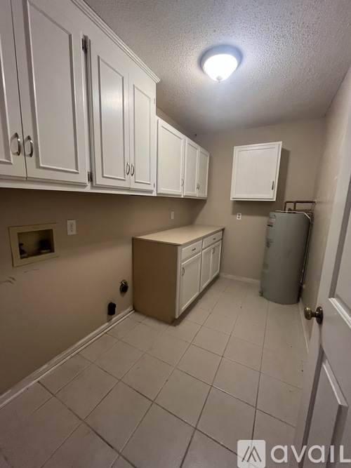 A kitchen with white cabinets and a tiled floor.