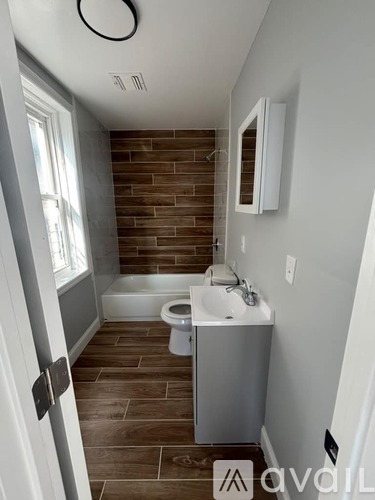 A bathroom with a toilet, sink, and a brick wall.