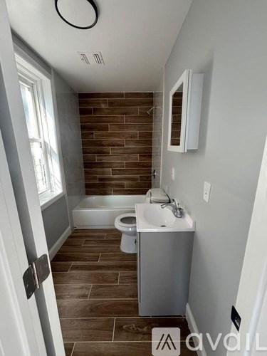 A bathroom with a toilet, sink, and a brick wall.