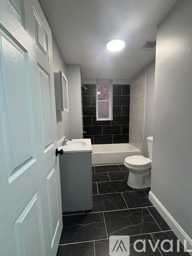 A bathroom with a toilet, sink, and bathtub.