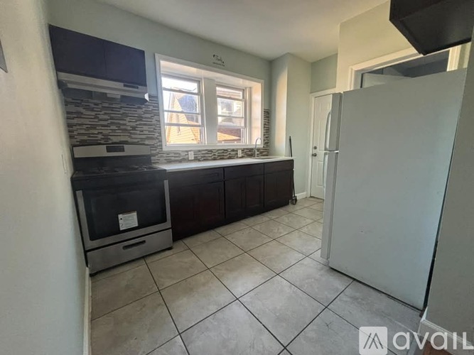 A kitchen with a refrigerator, oven, and microwave.