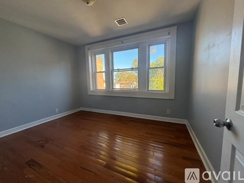 A room with wooden flooring and a large window.