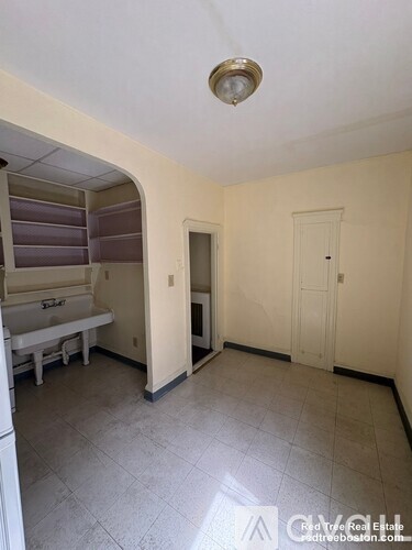 A small, empty room with a sink and a door.
