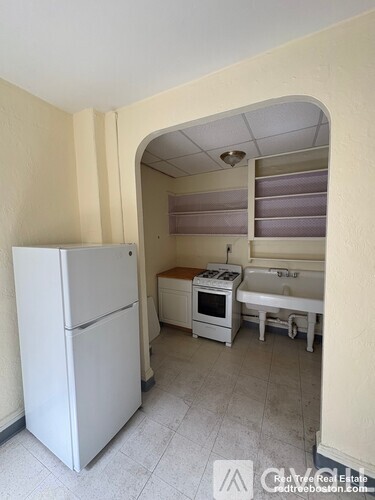 A kitchen with a white refrigerator, a white oven, and a white sink.