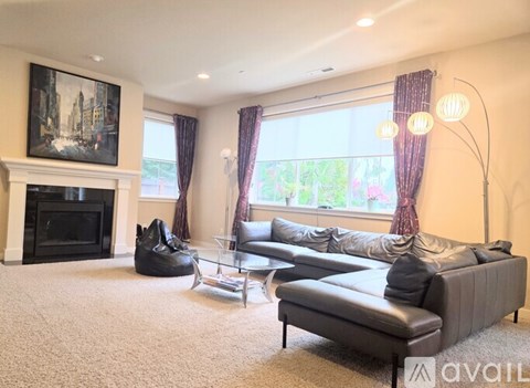 A living room with a fireplace and a large painting on the wall.