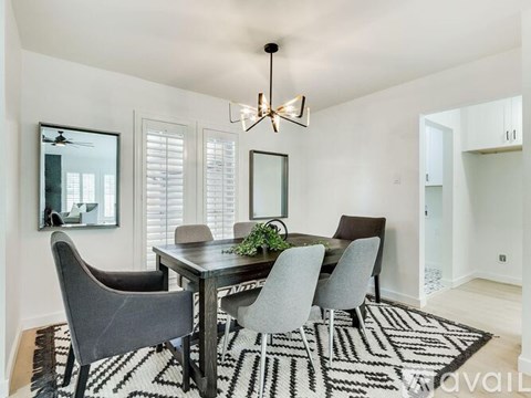A dining room with a table and chairs.