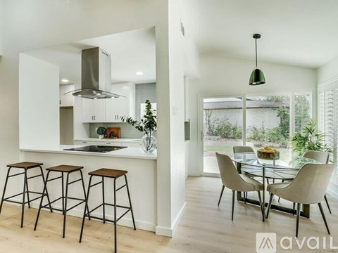 A modern kitchen with a bar area and a dining table set up.
