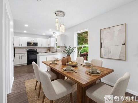 A dining room with a wooden table set for four.