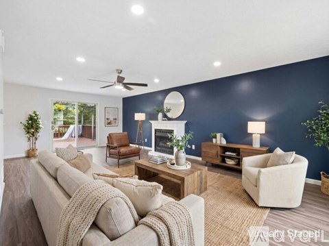 A living room with a beige couch and a wooden coffee table.
