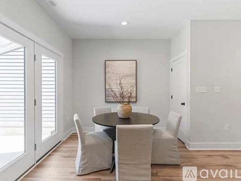 A dining room with a round table and chairs.