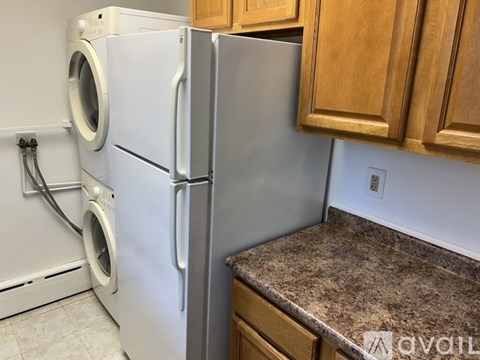 A white refrigerator and washing machine in a kitchen.