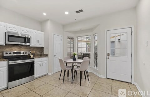 A kitchen with white cabinets and a black stove top oven.