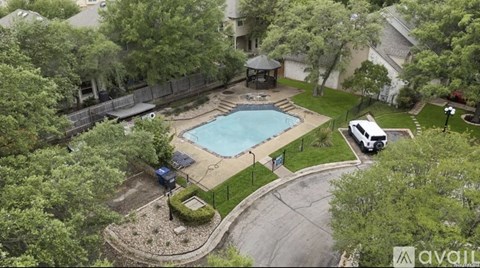 A backyard with a swimming pool and a gazebo.