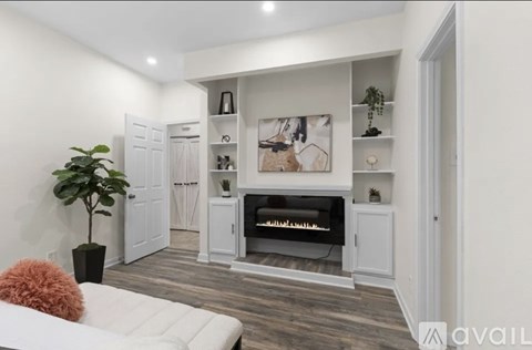 A living room with a white couch and a fireplace.