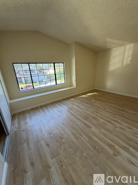 A room with wooden flooring and a window.