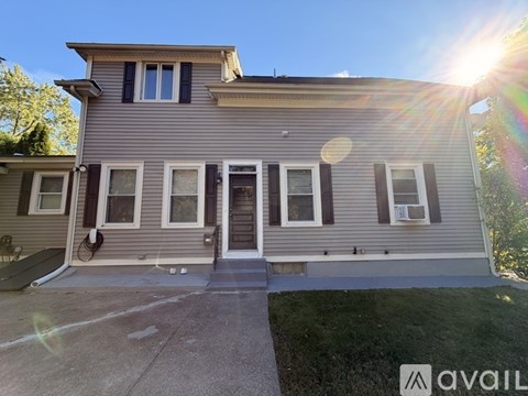 A house with a grey exterior and a white door is available for rent.