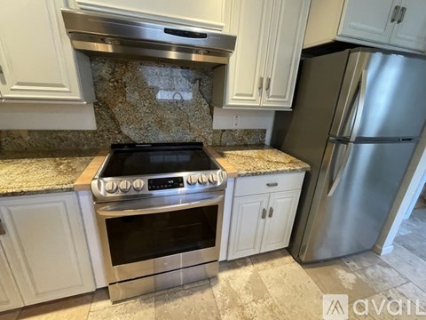 A kitchen with a stove top oven and a refrigerator.