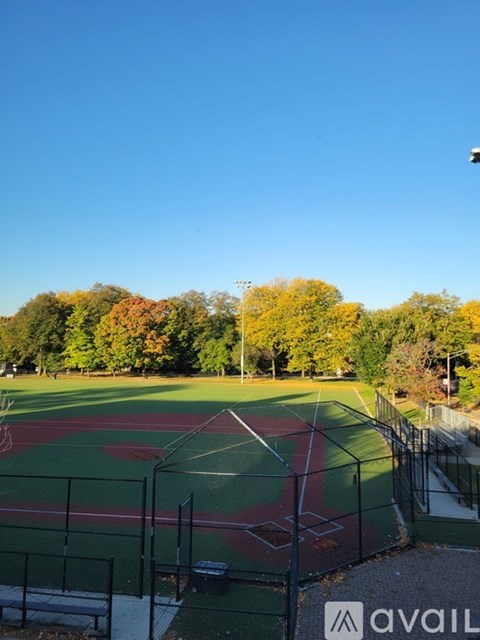 A tennis court surrounded by a fence and trees.