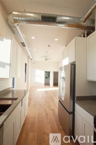 A kitchen with wooden floors and white cabinets.