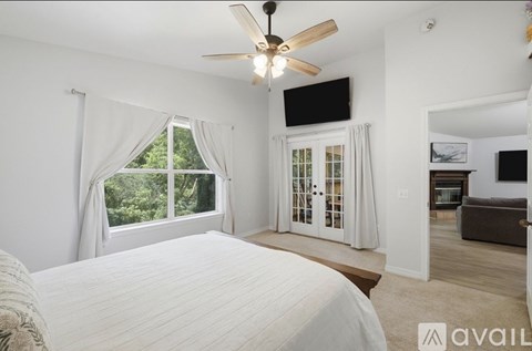 A bedroom with a large bed and a ceiling fan.