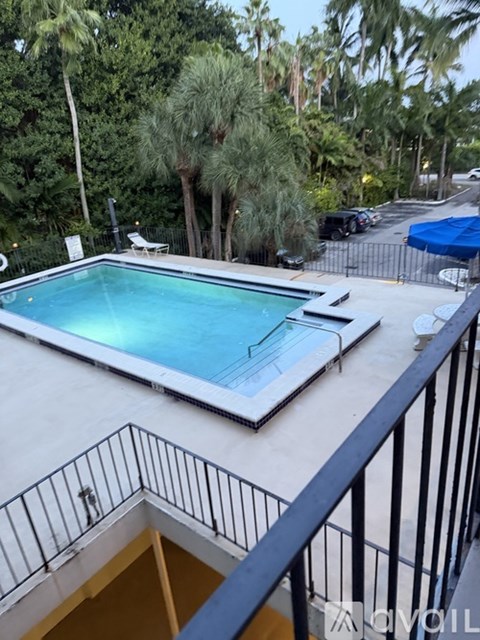 A pool on a balcony with a view of trees.