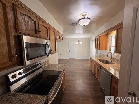 A kitchen with wooden cabinets and a granite countertop.