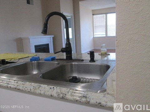 A kitchen sink with a faucet and a small fireplace in the corner.