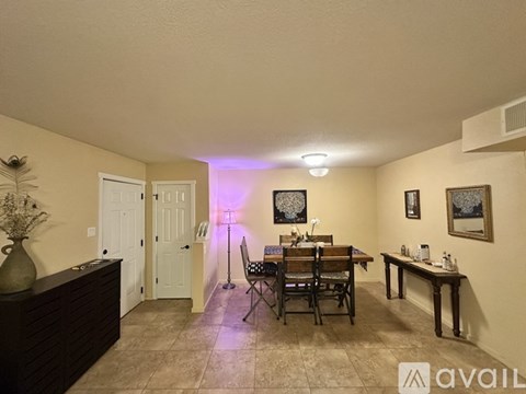 A dining room with a table set for two and a purple light.