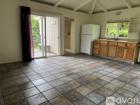 A kitchen with tile flooring and a white refrigerator.