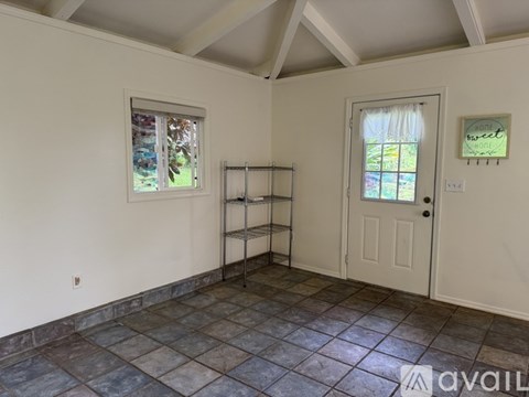 A room with a door, a window, and a tiled floor.
