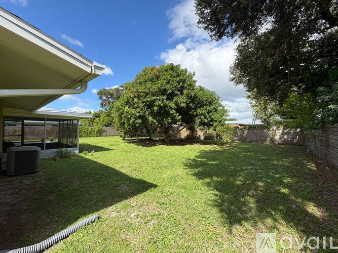 A backyard with a lawn and trees.