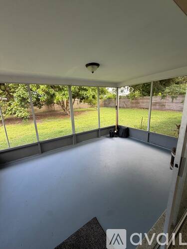 A room with a white ceiling and a window overlooking a green lawn.