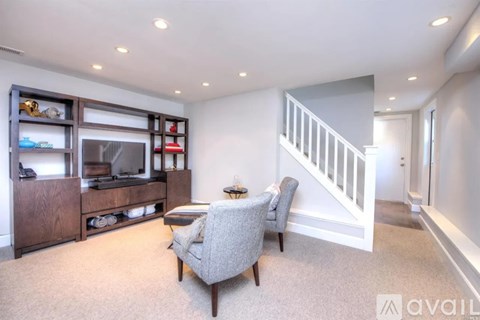 A living room with a grey sofa and a wooden entertainment center.