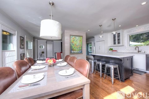 A modern dining room with a wooden table set for six.
