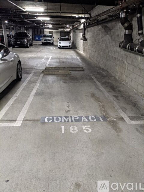 A parking garage with the words "COMPACT 185" painted on the ground.