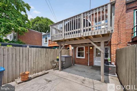 A backyard with a wooden deck and a fence.