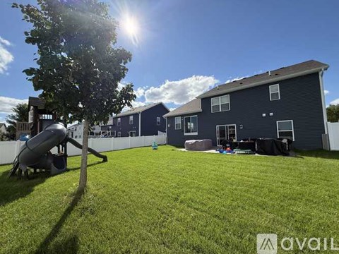 A sunny day at a backyard with a playground and a house.