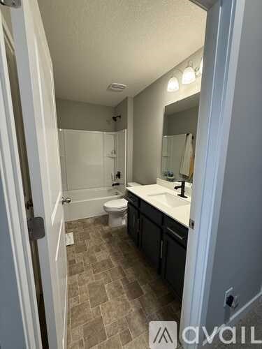 A bathroom with a toilet, sink, and mirror.