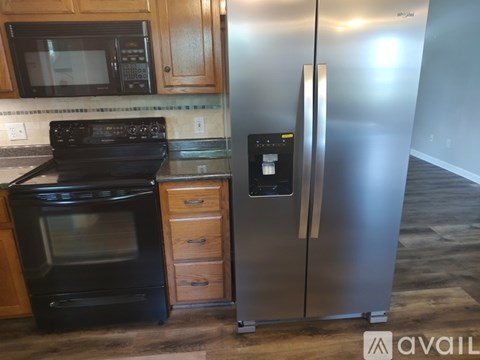 A kitchen with a black oven, a black microwave, a black fridge, and a black stove top.