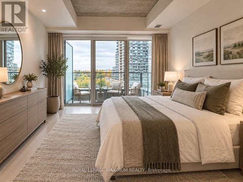 A bedroom with a large bed, a dresser, and a view of the city.