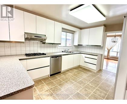 A kitchen with white cabinets and a tiled floor.