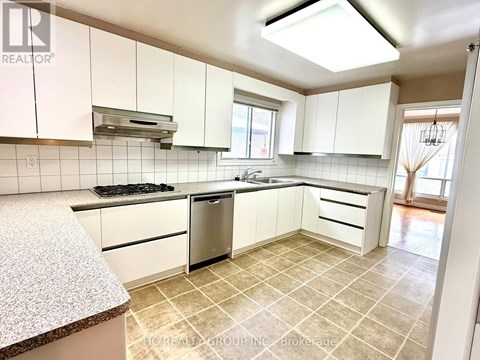 A kitchen with white cabinets and a tiled floor.