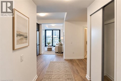 A hallway with a rug on the floor and a painting on the wall.